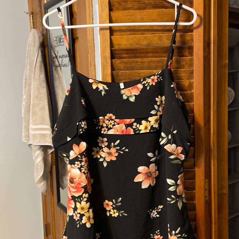Spaghetti strap, exposed shoulder tunic with floral design.